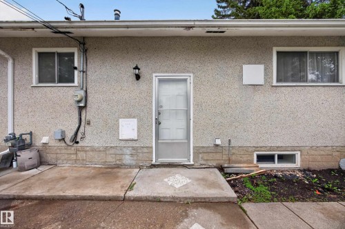 Rear stucco exterior with stone-finish foundation accent - 5216 104A Street, Edmonton, AB - Outdoor With Exterior