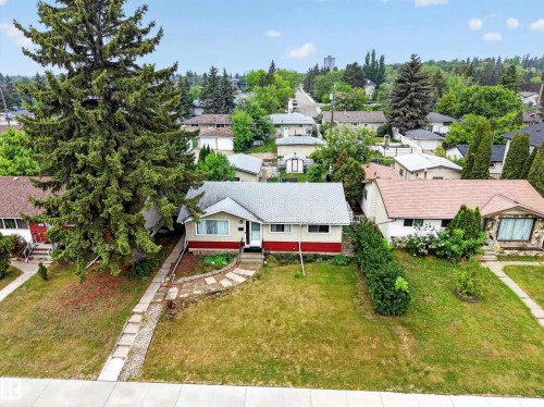 Single-story residence featuring a light-colored exterior with a red accent band and a light gray shingle roof - 5216 104A Street, Edmonton, AB - Outdoor