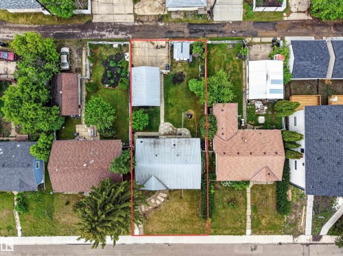 Expansive lot featuring a primary residence with a brown shingle roof, a detached garage, and a separate outbuilding - 5216 104A Street, Edmonton, AB - Outdoor