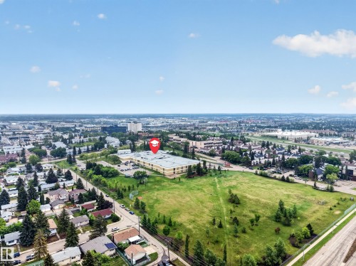 Aerial perspective showcasing a broad urban landscape with residential areas, commercial structures, and extensive green spaces - 5216 104A Street, Edmonton, AB - Outdoor With View
