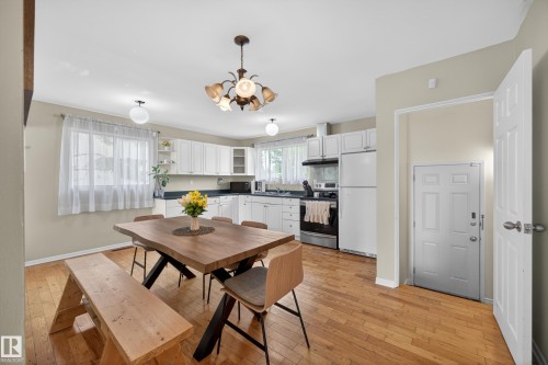 Kitchen and dining area featuring wood-finish flooring - 5216 104A Street, Edmonton, AB - Indoor