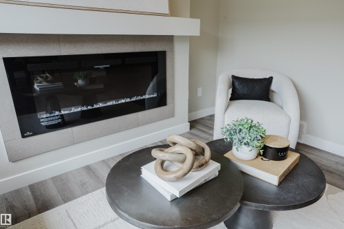 Modern linear electric fireplace with a tile surround and a clean white mantel - 9142 Pear Drive, Edmonton, AB - Indoor Photo Showing Living Room With Fireplace