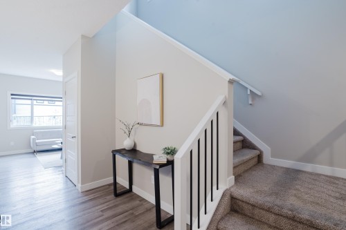 Staircase featuring carpeted treads, white risers, and a white balustrade with black spindles - 9142 Pear Drive, Edmonton, AB - Indoor Photo Showing Other Room