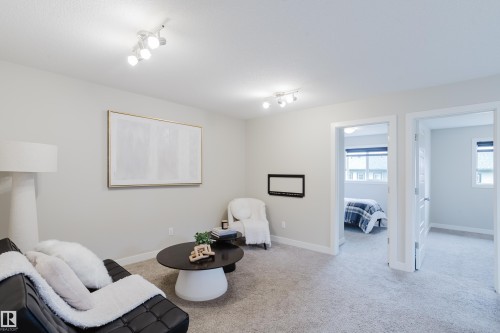 Carpeted interior space featuring track lighting, light-toned walls, and white trim - 9142 Pear Drive, Edmonton, AB - Indoor