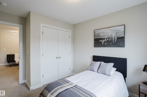 Bedroom featuring neutral wall paint, carpeted flooring, and a double-door closet with horizontal paneling - 9142 Pear Drive, Edmonton, AB - Indoor Photo Showing Bedroom