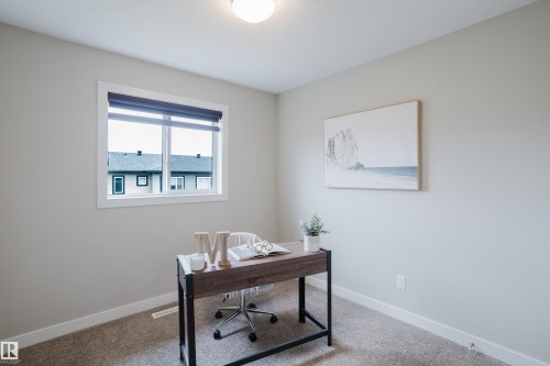 Bright interior space featuring a window with white trim, neutral wall paint, and a textured carpet floor - 9142 Pear Drive, Edmonton, AB - Indoor Photo Showing Office