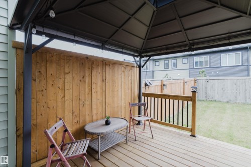 Expansive wooden deck featuring a gazebo with string lighting, a wooden privacy fence, and a grassy yard - 9142 Pear Drive, Edmonton, AB - Outdoor With Deck Patio Veranda With Exterior