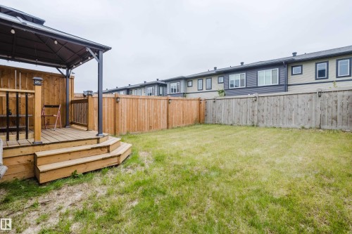 Private backyard with a wooden deck featuring tiered steps, a built-in privacy wall, and a gazebo structure - 9142 Pear Drive, Edmonton, AB - Outdoor With Deck Patio Veranda With Exterior