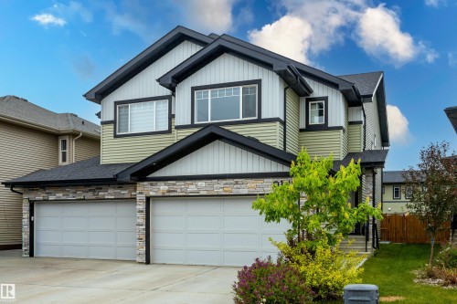 Two-story home featuring a dual garage, stone facade accents, and horizontal siding - 9142 Pear Drive, Edmonton, AB - Outdoor