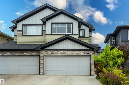 Contemporary two-story residence featuring a dual-tone facade, stone accents, and a double garage - 9142 Pear Drive, Edmonton, AB - Outdoor With Exterior