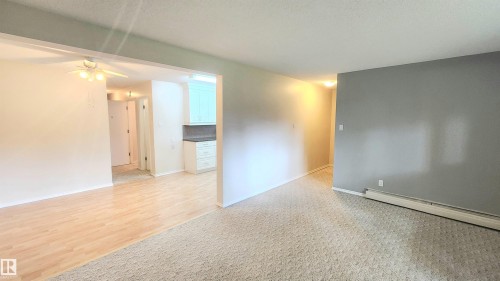 Open concept living area featuring a ceiling fan, wood-finish flooring, and light-toned walls - 8824 90 Street, Edmonton, AB 