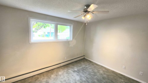 Interior space featuring light-colored walls and textured carpeting - 8824 90 Street, Edmonton, AB 