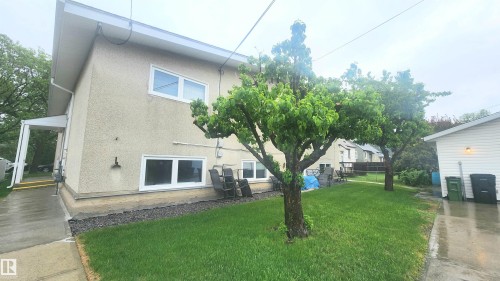 Stucco exterior with white trim windows and a covered side entrance - 8824 90 Street, Edmonton, AB 