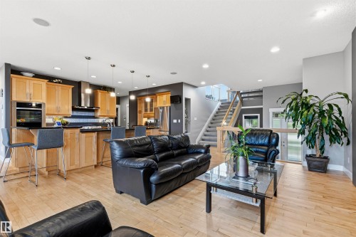Open-concept living area with light-toned wood-finish flooring - 5709 Mcluhan Bay, Edmonton, AB 