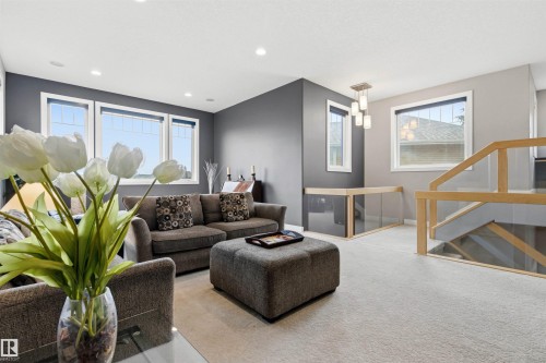 Recessed lighting and multiple windows illuminate this carpeted living space - 5709 Mcluhan Bay, Edmonton, AB 