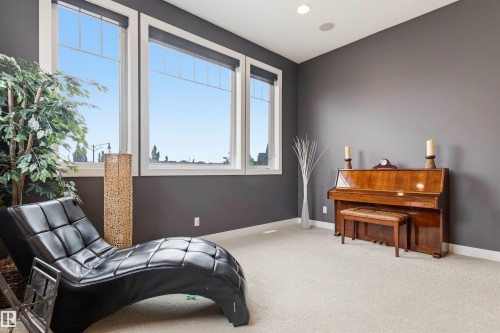 Spacious room featuring three large windows, dark gray walls, recessed lighting, and light-toned carpeting - 5709 Mcluhan Bay, Edmonton, AB 