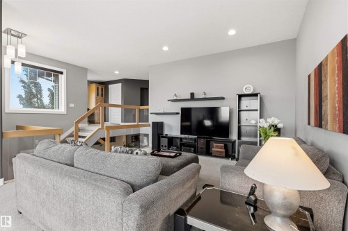 Living area featuring light gray walls, recessed lighting, and a vaulted ceiling - 5709 Mcluhan Bay, Edmonton, AB 