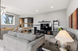 Living area featuring light gray walls, recessed lighting, and a vaulted ceiling - 