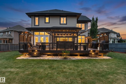Spacious rear deck featuring dark wood tones, integrated string lighting, and built-in step lighting - 5709 Mcluhan Bay, Edmonton, AB 