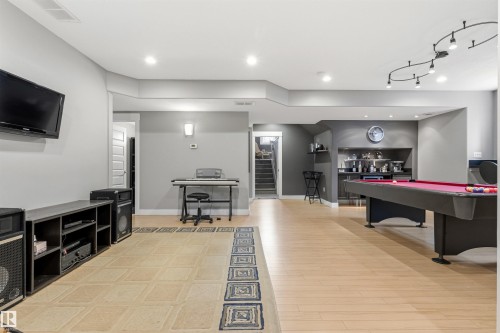 Spacious entertainment room featuring recessed lighting, a built-in wet bar, light wood-finish flooring, and a dedicated billiards area - 5709 Mcluhan Bay, Edmonton, AB 