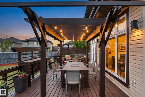 Expansive wood-finish deck featuring a dark wood pergola with string lighting - 5709 Mcluhan Bay, Edmonton, AB 