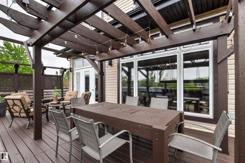 Expansive outdoor deck featuring a dark-stained wood pergola and lattice privacy screens - 5709 Mcluhan Bay, Edmonton, AB 