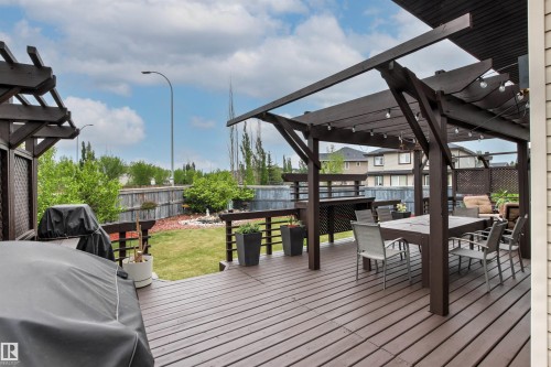 Expansive multi-level wood deck featuring a pergola with string lighting - 5709 Mcluhan Bay, Edmonton, AB 