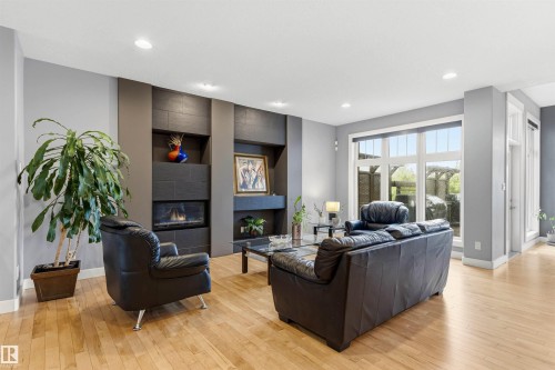 Living area featuring a modern fireplace surround with integrated shelving and a gas insert - 5709 Mcluhan Bay, Edmonton, AB 