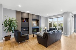 Living area featuring a modern fireplace surround with integrated shelving and a gas insert - 