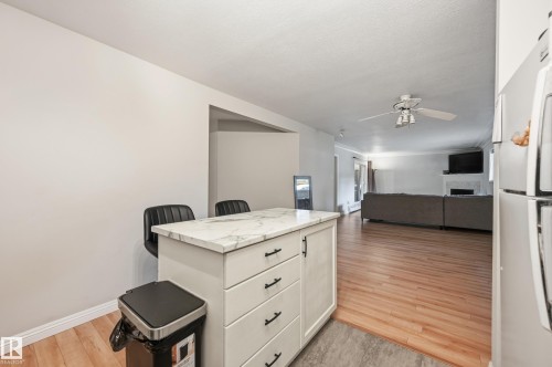 Kitchen island with a light-toned countertop, multiple drawers, and cabinet storage - 33 9914 80 Avenue, Edmonton, AB - Indoor