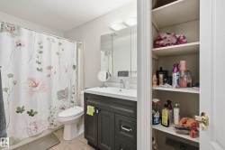 Bathroom featuring a dark vanity with a white countertop, an integrated sink, and chrome fixtures - 