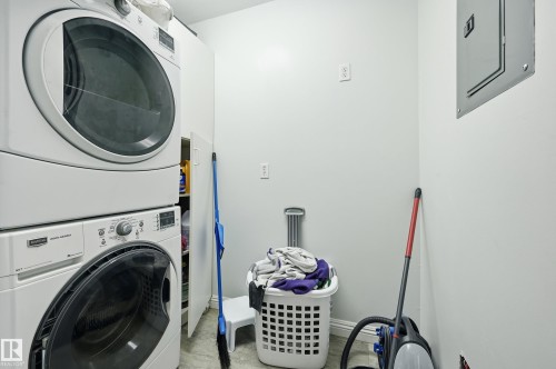 Dedicated laundry area featuring stacked front-load washer and dryer units - 33 9914 80 Avenue, Edmonton, AB - Indoor Photo Showing Laundry Room