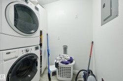Dedicated laundry area featuring stacked front-load washer and dryer units - 
