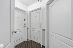 Corridor featuring wood-finish flooring and multiple white paneled doors - 