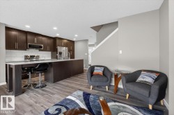 Open-concept kitchen featuring dark wood-finish cabinetry, stainless steel appliances, and a white subway tile backsplash - 