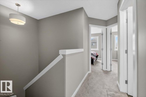 Upper-level hallway featuring a neutral color palette, plush carpeting, and multiple doorways - 223 40A Avenue, Edmonton, AB - Indoor Photo Showing Other Room