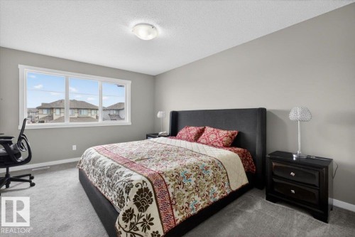 Carpeted room featuring a large window, neutral wall paint, and a white ceiling - 223 40A Avenue, Edmonton, AB - Indoor Photo Showing Bedroom