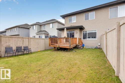 Rear exterior featuring a wooden deck with railing, a sliding glass door, and vinyl siding - 223 40A Avenue, Edmonton, AB - Outdoor With Deck Patio Veranda