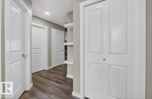 Hallway featuring wood-finish flooring, recessed lighting, white panel doors, and built-in shelving - 223 40A Avenue, Edmonton, AB - Indoor Photo Showing Other Room