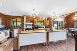 Kitchen featuring wood-finish flooring, log walls, and white ceiling with recessed lighting - 