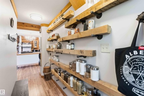 Expansive wall-mounted shelving crafted from substantial wood planks and industrial-style pipe supports - #17 A 15031 Twp Road 462, Rural Wetaskiwin County, AB - Indoor