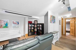 Recreational room featuring a ceiling-mounted projection screen, track lighting, and wood-finish flooring - 