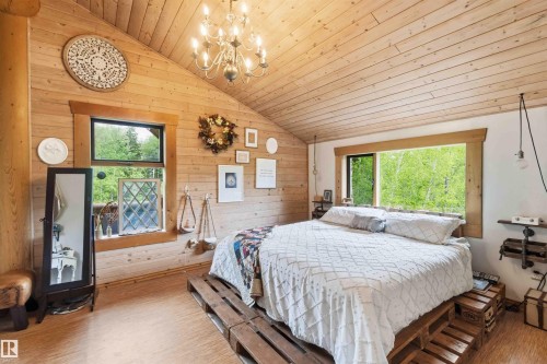 Wood-paneled bedroom featuring an angled ceiling and wood-finish flooring - #17 A 15031 Twp Road 462, Rural Wetaskiwin County, AB - Indoor Photo Showing Other Room