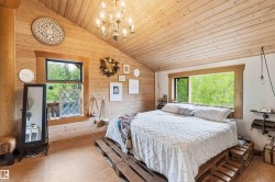 Wood-paneled bedroom featuring an angled ceiling and wood-finish flooring - 