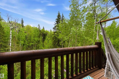 Wood-plank balcony with a log-style railing and a natural tree canopy backdrop - #17 A 15031 Twp Road 462, Rural Wetaskiwin County, AB - Indoor Photo Showing Bathroom