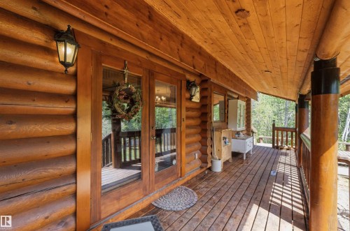 Expansive covered deck featuring natural wood flooring and log cabin construction - #17 A 15031 Twp Road 462, Rural Wetaskiwin County, AB - Outdoor