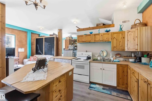 Open-concept kitchen featuring wood cabinetry, coordinating wood-finish countertops, and a white appliance suite - #17 A 15031 Twp Road 462, Rural Wetaskiwin County, AB - Indoor