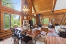Open-concept dining and living area featuring extensive wood-finish flooring, exposed wood beam ceilings, and log wall construction - #17 A 15031 Twp Road 462, Rural Wetaskiwin County, AB  - Indoor Photo Showing Dining Room 