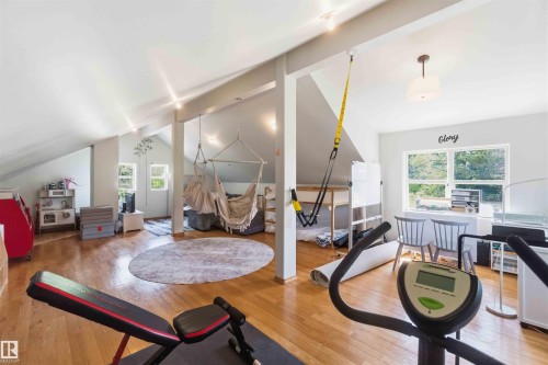 Expansive attic conversion featuring hardwood flooring, sloped ceilings with recessed lighting, multiple windows, and a dedicated desk area - #17 A 15031 Twp Road 462, Rural Wetaskiwin County, AB - Indoor Photo Showing Other Room