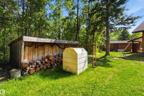 Rustic wood-sided storage shed with a lean-to roof, positioned on a grassy lawn - #17 A 15031 Twp Road 462, Rural Wetaskiwin County, AB - Outdoor With Exterior